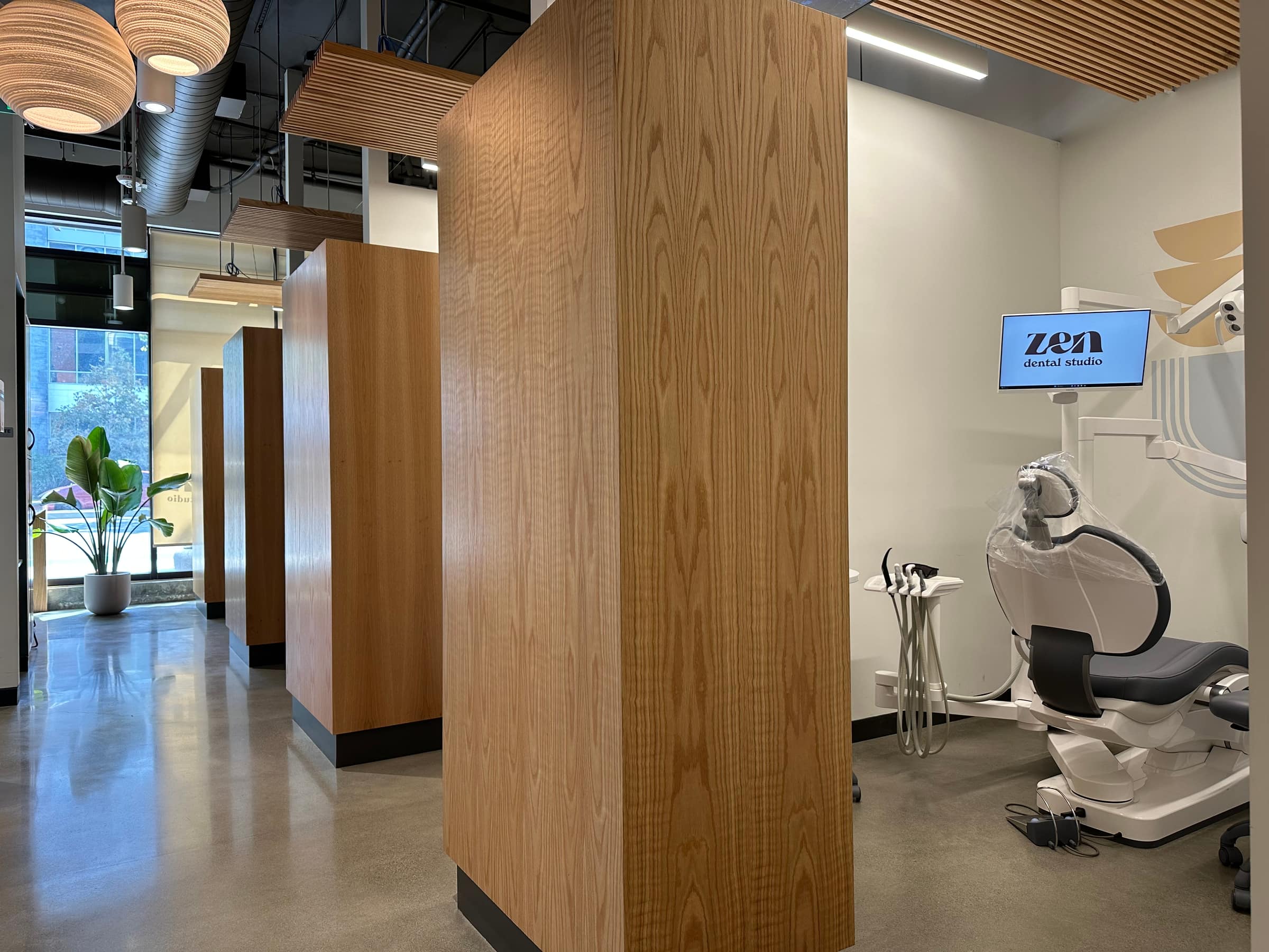 A Mountain View treatment bay with oak partitions, an oak ceiling, and a chairside screen