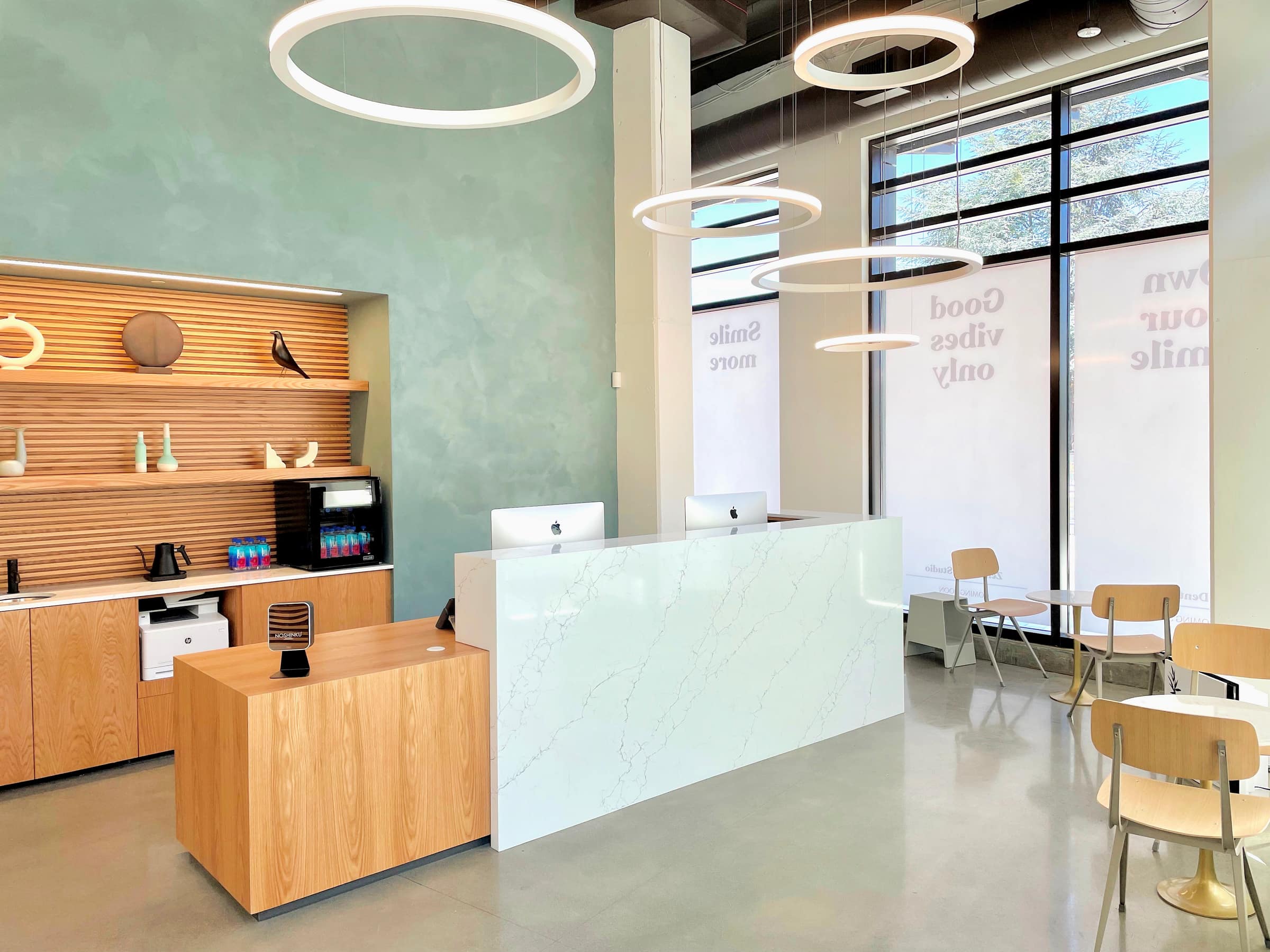 The Mountain View reception with sage walls, an oak slat wall, and a marble desk